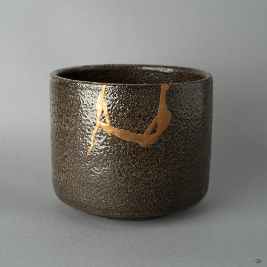 Shigaraki matcha bowl restored with 24K gold kintsugi, its surface revealing a quiet beauty shaped by urushi craftsmanship.