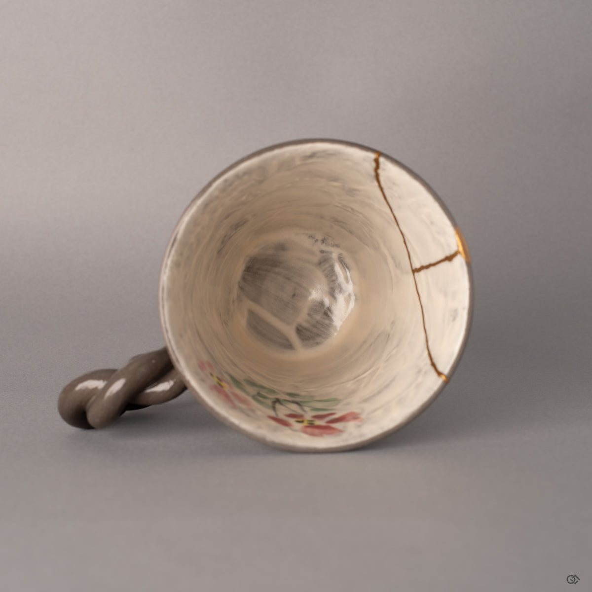Looking into the mug from above, kintsugi lines converge like quiet rivers, marking where fractures became history made visible.