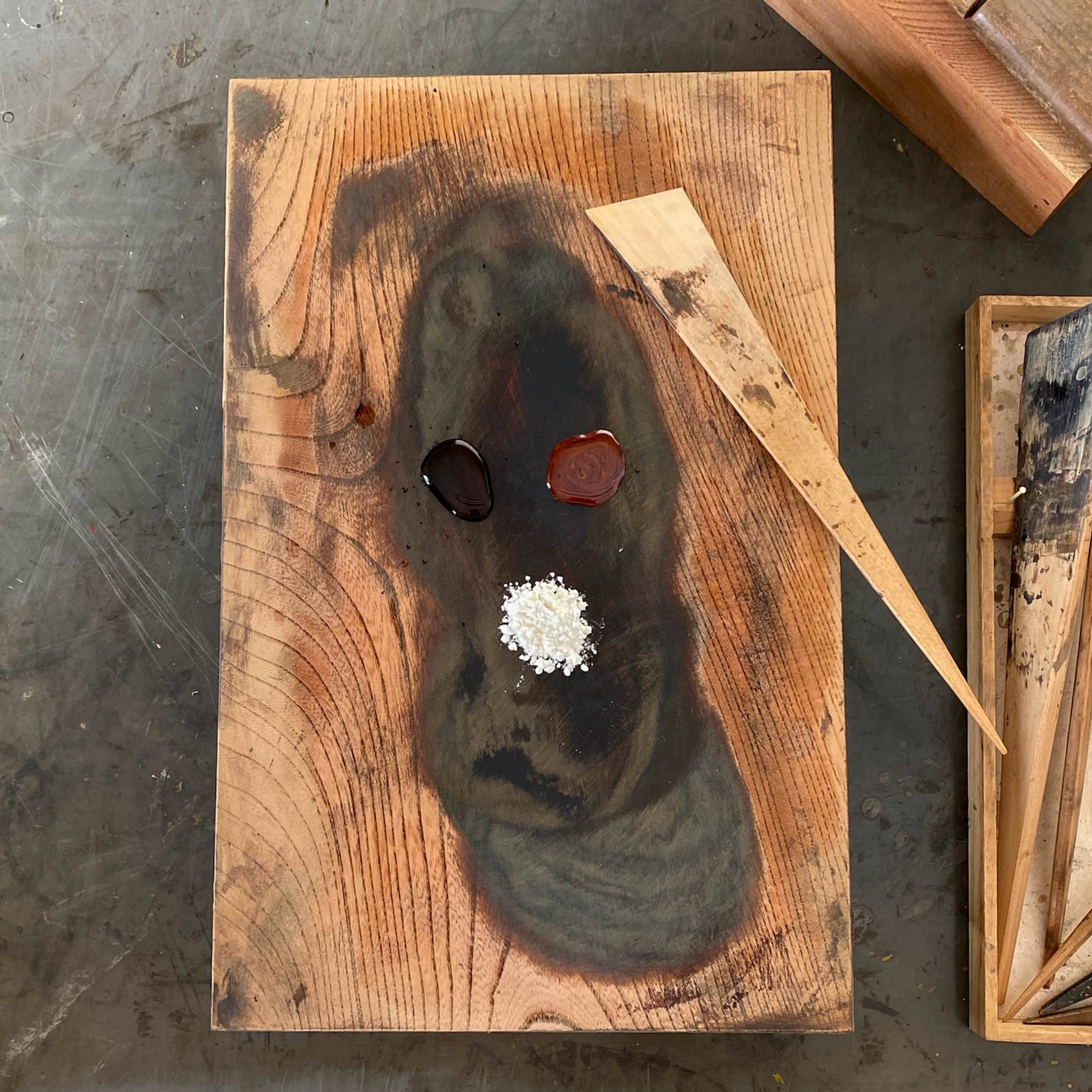 Mugi-urushi natural lacquer glue made from raw urushi, water, and wheat flour, arranged on a wooden board with a bamboo spatula for kintsugi restoration