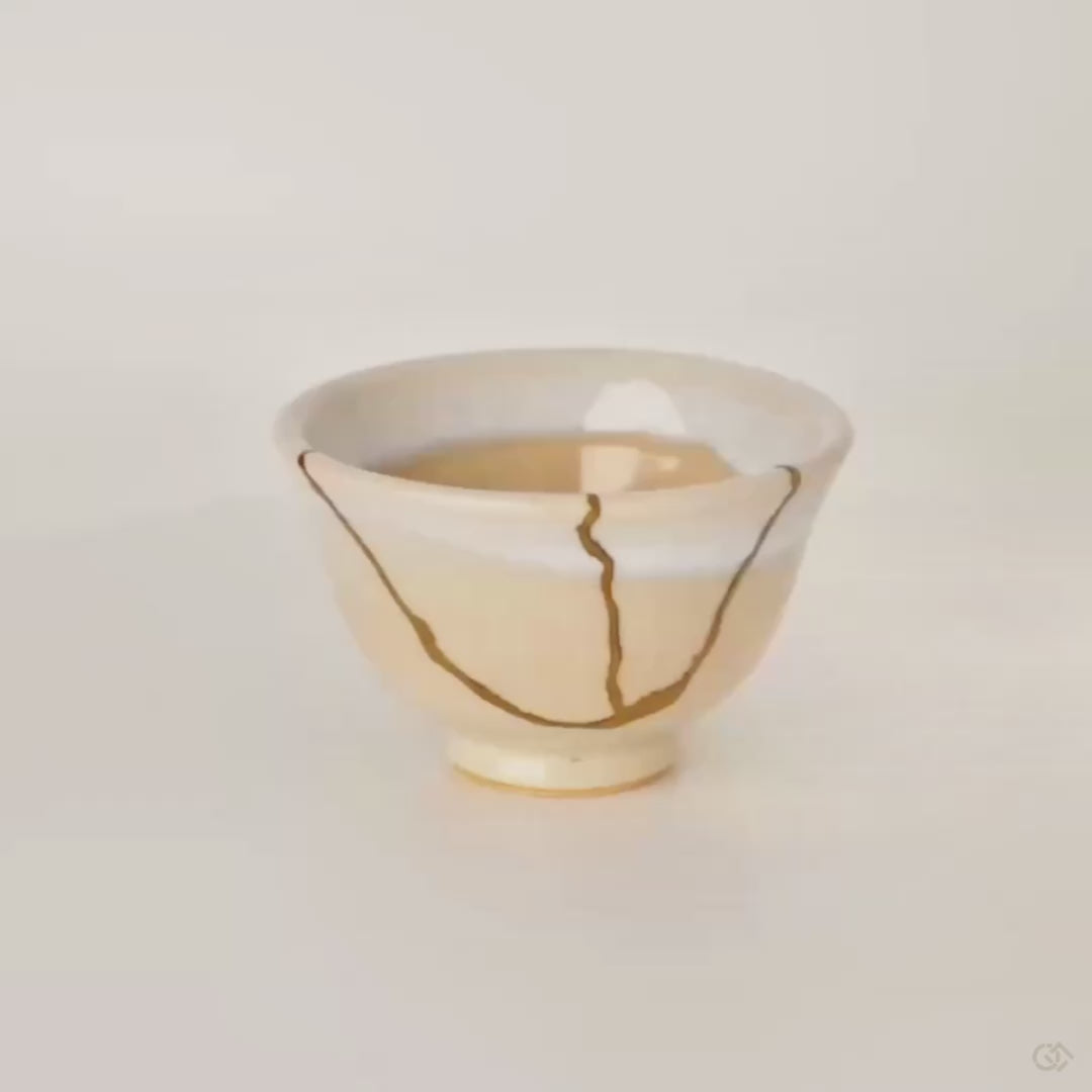 This Hagi kintsugi cup turns slowly, revealing gold seams that honor the earthenware's seven transformations.