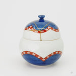 Rotating view of an Arita ware lidded bowl in white porcelain with 24K gold kintsugi seams on the lid, turning to show the full restoration.