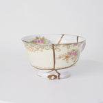 Rotating view of a kintsugi tea cup in cream Early Noritake porcelain with natural urushi and 24K gold seams, turning to show the full restoration.