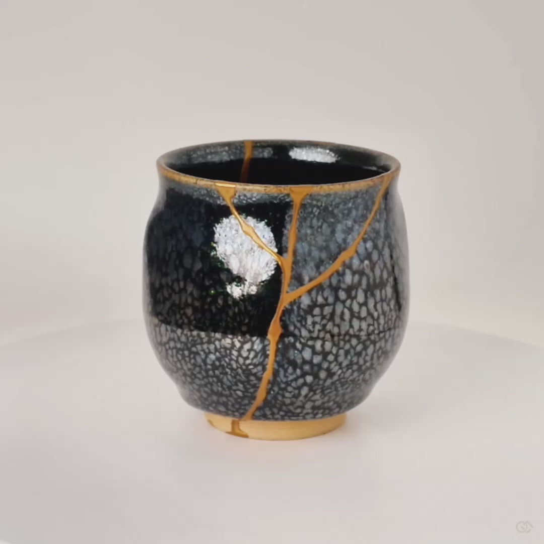 The tenmoku Kyoto cup turns, silver stars and kintsugi gold appearing in rhythm, tactile history revealed from every angle.