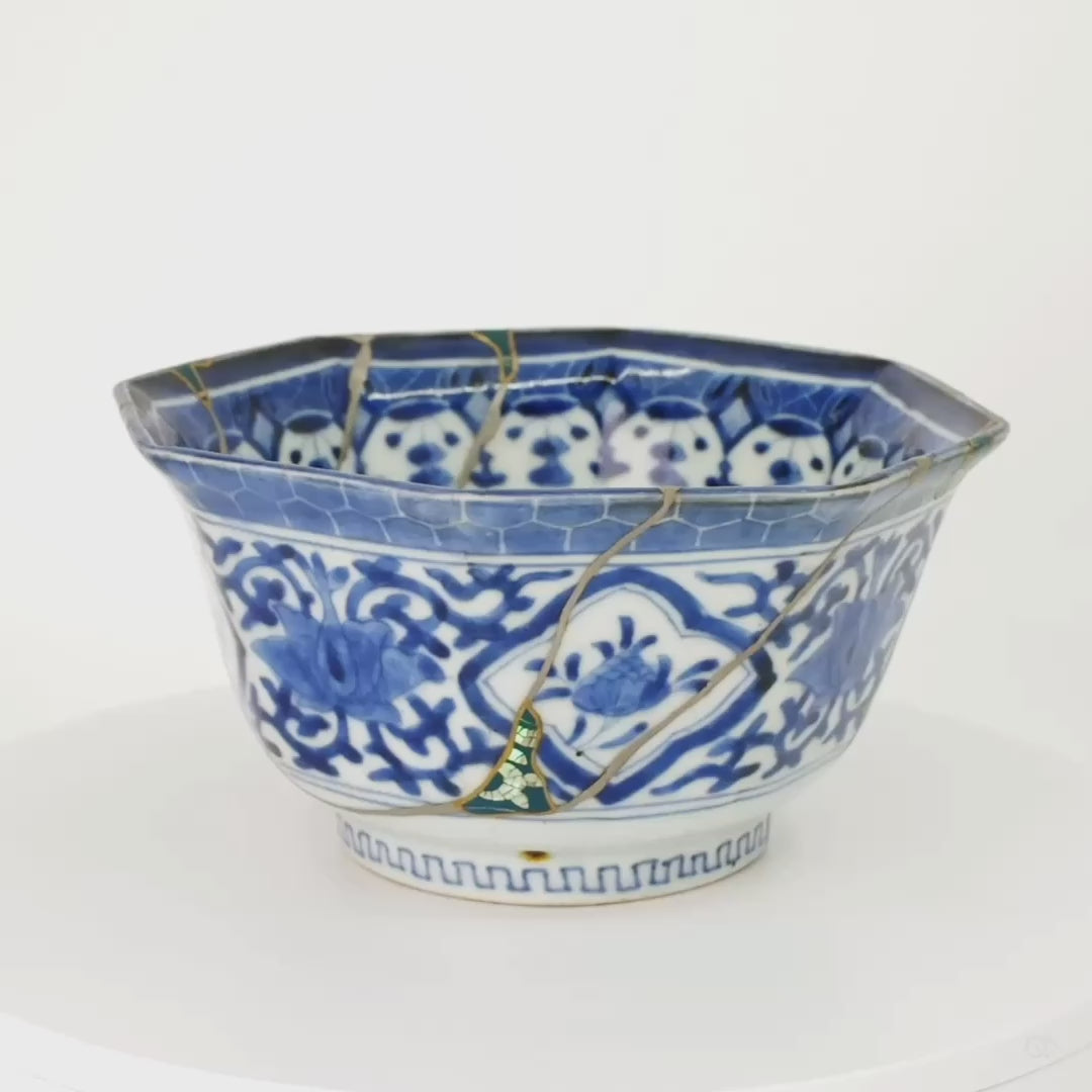 Rotating video of the octagonal Ko-Imari kintsugi bowl, blue-and-white porcelain turning to reveal green urushi and raden panels, 24K gold outlines and pure silver seams from every side.