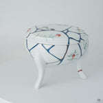 Rotating view of an Arita ware lidded bowl in white porcelain with 24K gold kintsugi seams and blue urushi lines, turning to show the full restoration.