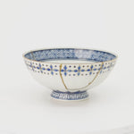 A 360-degree turn of the kintsugi rice bowl, gold seams and blue diamonds revolving slowly into view, scars as beauty seen from every side.