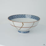 Rotation video of a Kyoto ware white porcelain rice bowl with cobalt lattice rim, showing its 24K gold kintsugi restoration in natural urushi from all sides.