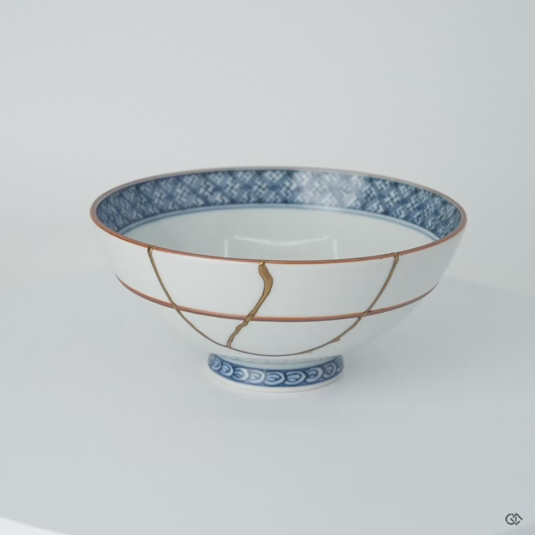 Rotation video of a Kyoto ware white porcelain rice bowl with cobalt lattice rim, showing its 24K gold kintsugi restoration in natural urushi from all sides.