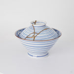 Rotation video of a kintsugi bowl with lid in Arita porcelain, natural urushi and 24K gold lines turning across the blue rings of the lid.