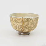 A slow 360-degree turn of the kintsugi matcha bowl, the gold seam circling past carved spirals, history made visible.