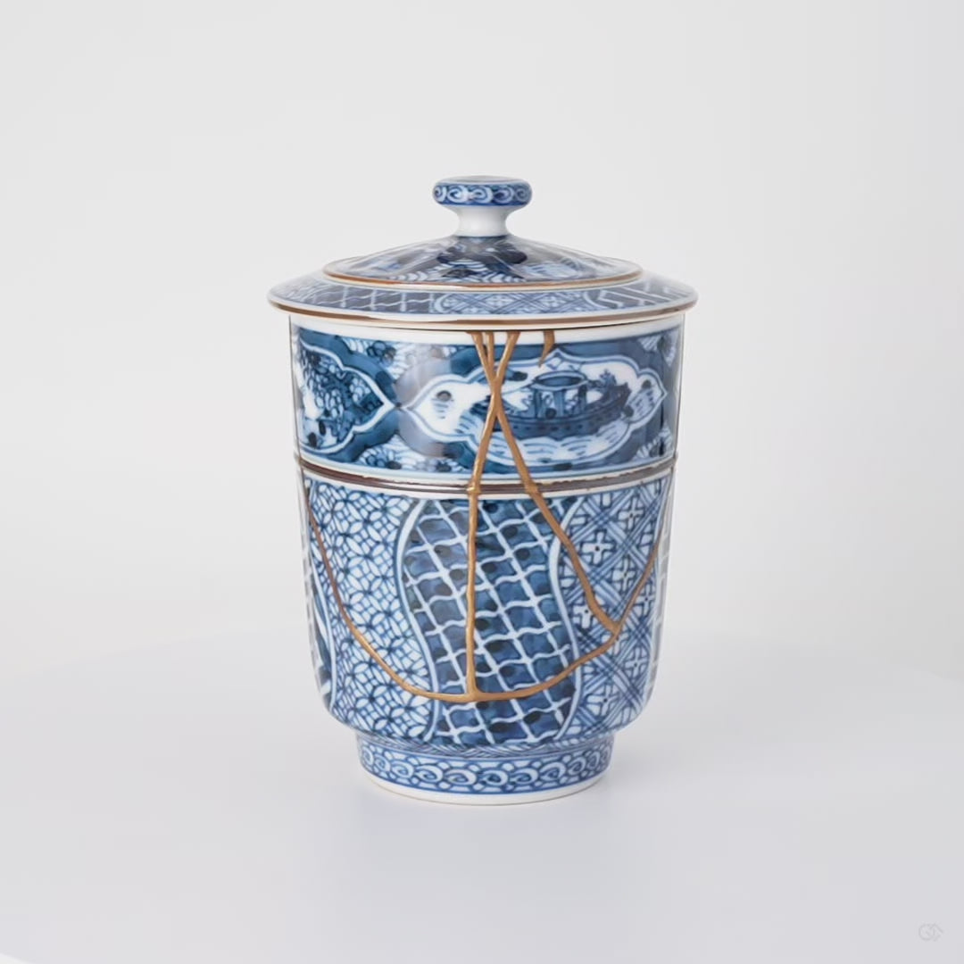 Rotation video of a kintsugi lidded tea cup in Kyoto ware, urushi and 24K gold seams crossing the shonzui panels and sansui band.