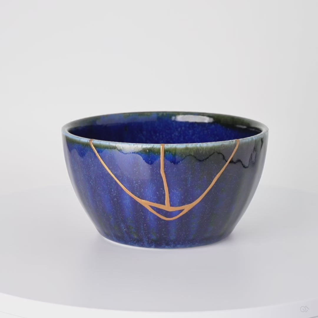 Rotation video of a Japanese kintsugi bowl in Mino ware, the urushi and 24K gold seam crossing the starry kamahen glaze and green rim.