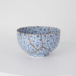 Rotation video of a kintsugi tea cup in Kyoto ware, the urushi and 24K gold seams circling its cherry-blossom porcelain.
