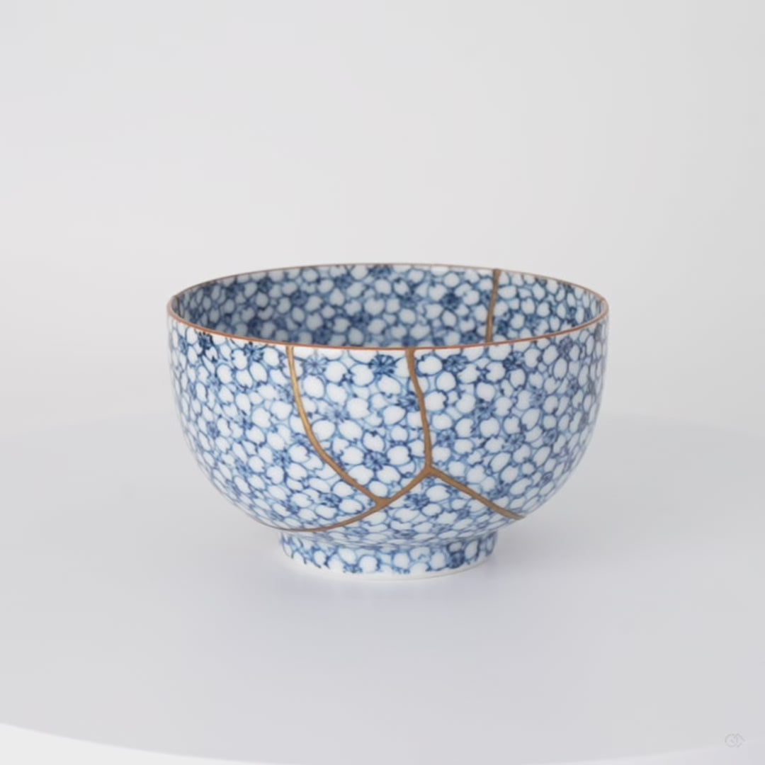 Rotation video of a kintsugi tea cup in Kyoto ware, the urushi and 24K gold seams circling its cherry-blossom porcelain.