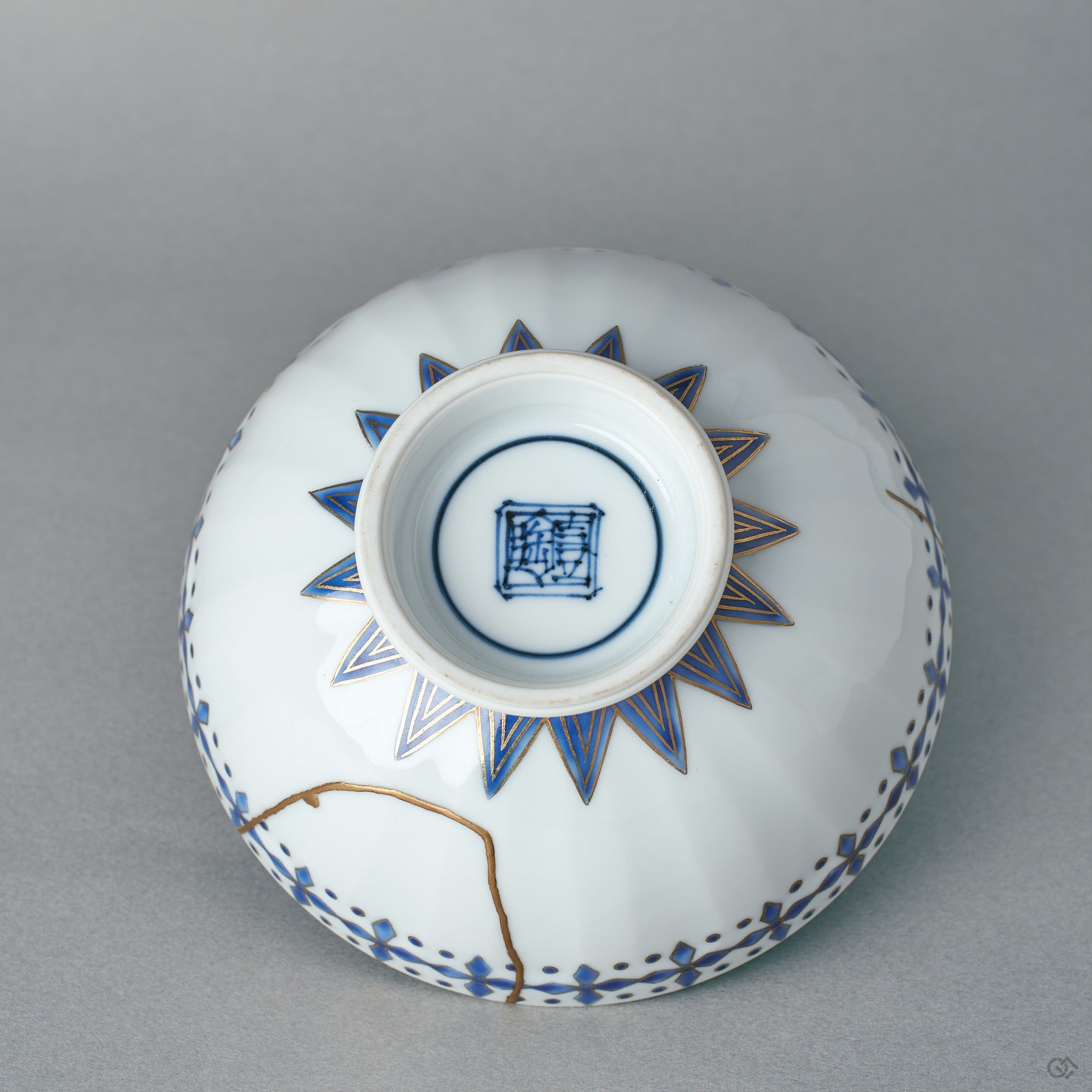 The underside of the kintsugi Kyoto rice bowl shows the glazed foot ring and maker's care, museum-quality craftsmanship in a humble form.