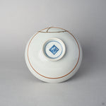 Underside of a Kyoto ware porcelain rice bowl with a painted mark inside the footring, the 24K gold kintsugi seam reaching over the white glazed base.