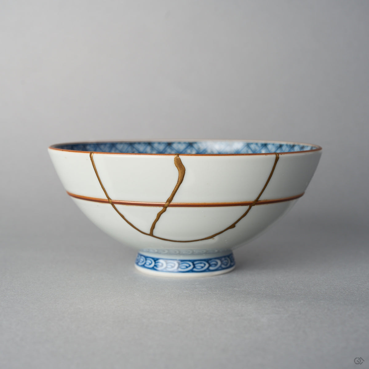 Front view of a Kyoto ware white porcelain rice bowl with red accent lines, a branching 24K gold kintsugi seam descending across the exterior glaze.