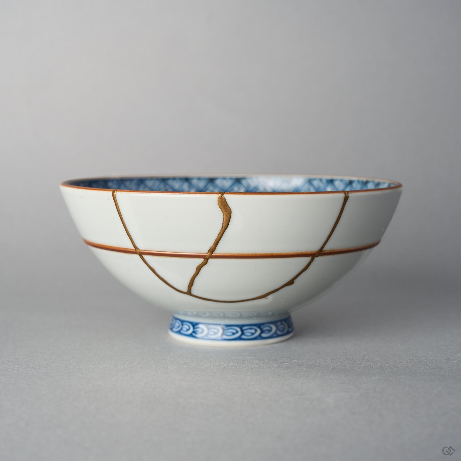 Front view of a Kyoto ware white porcelain rice bowl with red accent lines, a branching 24K gold kintsugi seam descending across the exterior glaze.