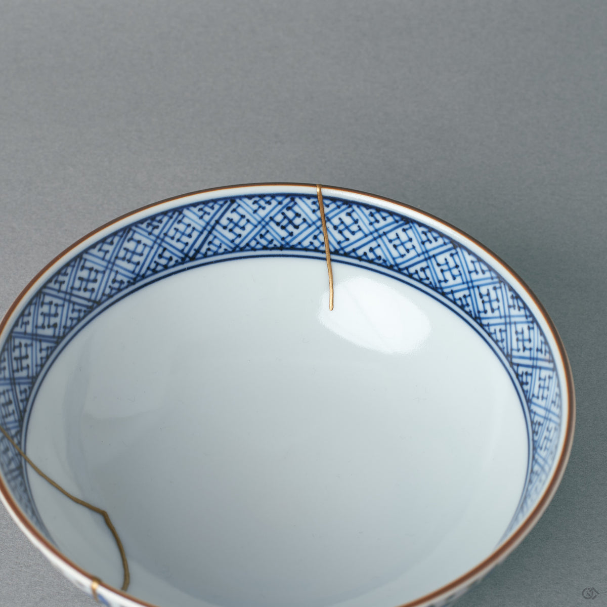 Close interior view of the kintsugi bowl, the roiro-polished gold catching light against white porcelain, a soulful object for daily use.