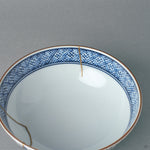 Close interior view of the kintsugi bowl, the roiro-polished gold catching light against white porcelain, a soulful object for daily use.