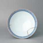 Viewed from above, the kintsugi rice bowl reveals its blue diaper-pattern interior and gold rim line, refined elegance in a circle of porcelain.