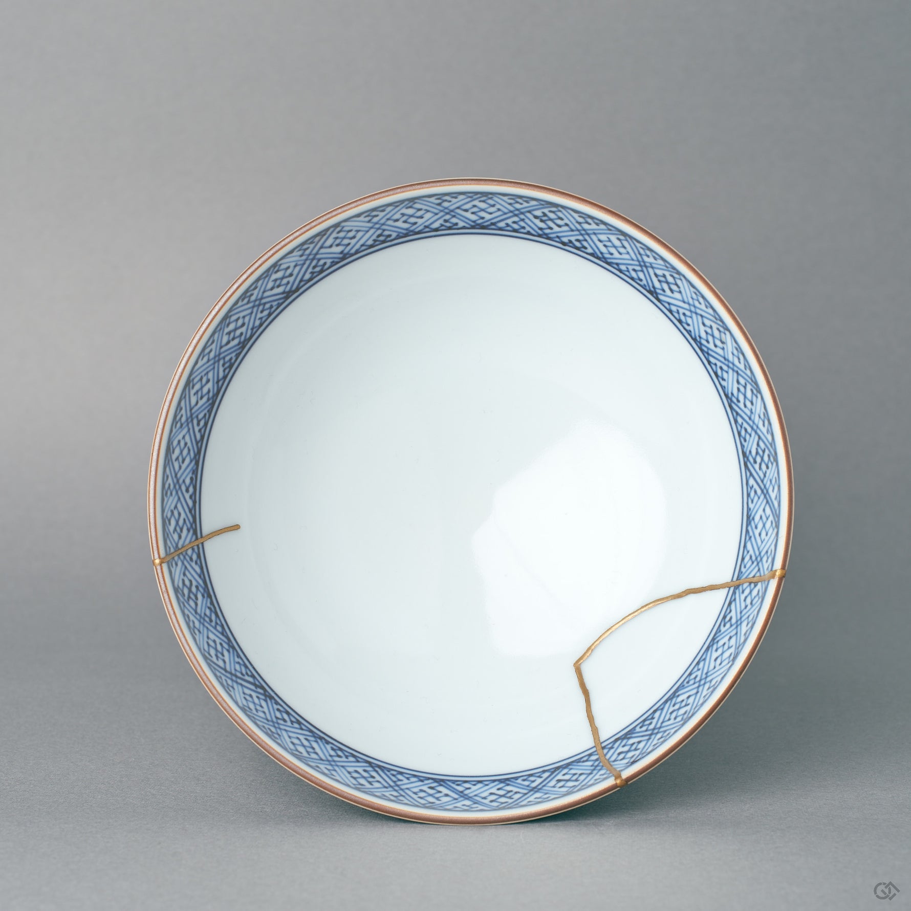 Viewed from above, the kintsugi rice bowl reveals its blue diaper-pattern interior and gold rim line, refined elegance in a circle of porcelain.