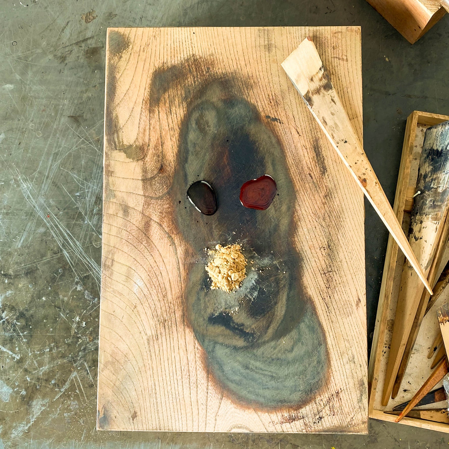 Sabi-urushi lacquer paste made from raw urushi, water, and tonoko clay powder, presented on a wooden board with a bamboo spatula for surface refinement in kintsugi