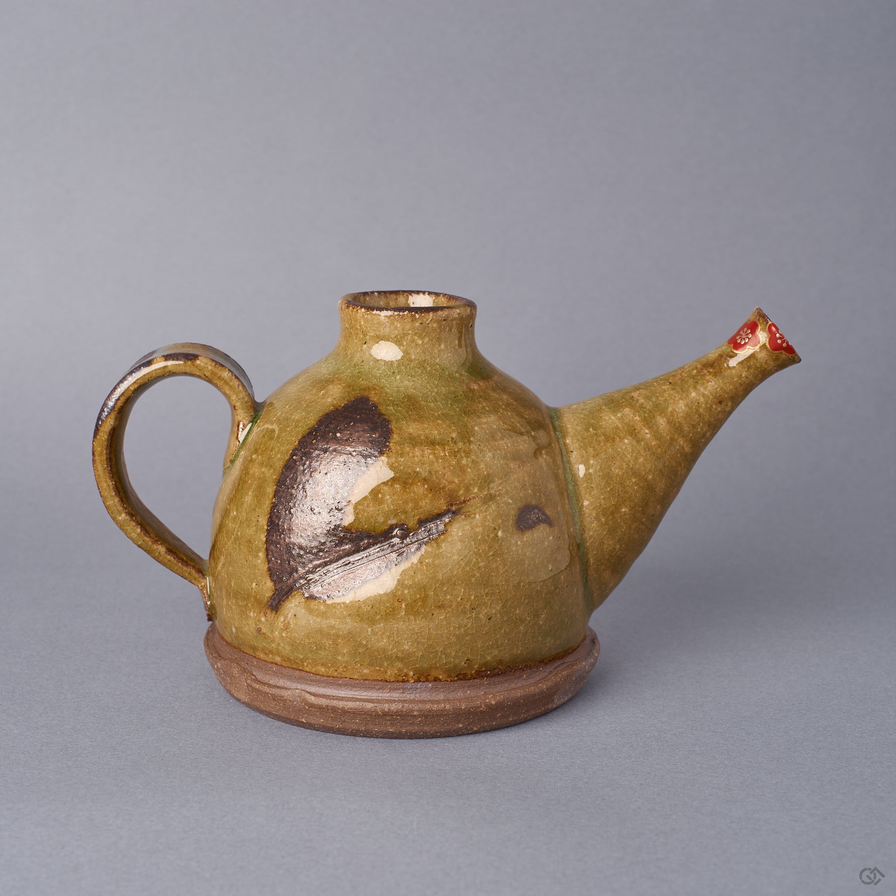 Kyoto ware earthenware sake carafe in ochre Oribe-green crackle glaze, looped handle and long spout, a plum blossom restored at the spout tip in 24K gold with a silver heart, front view.