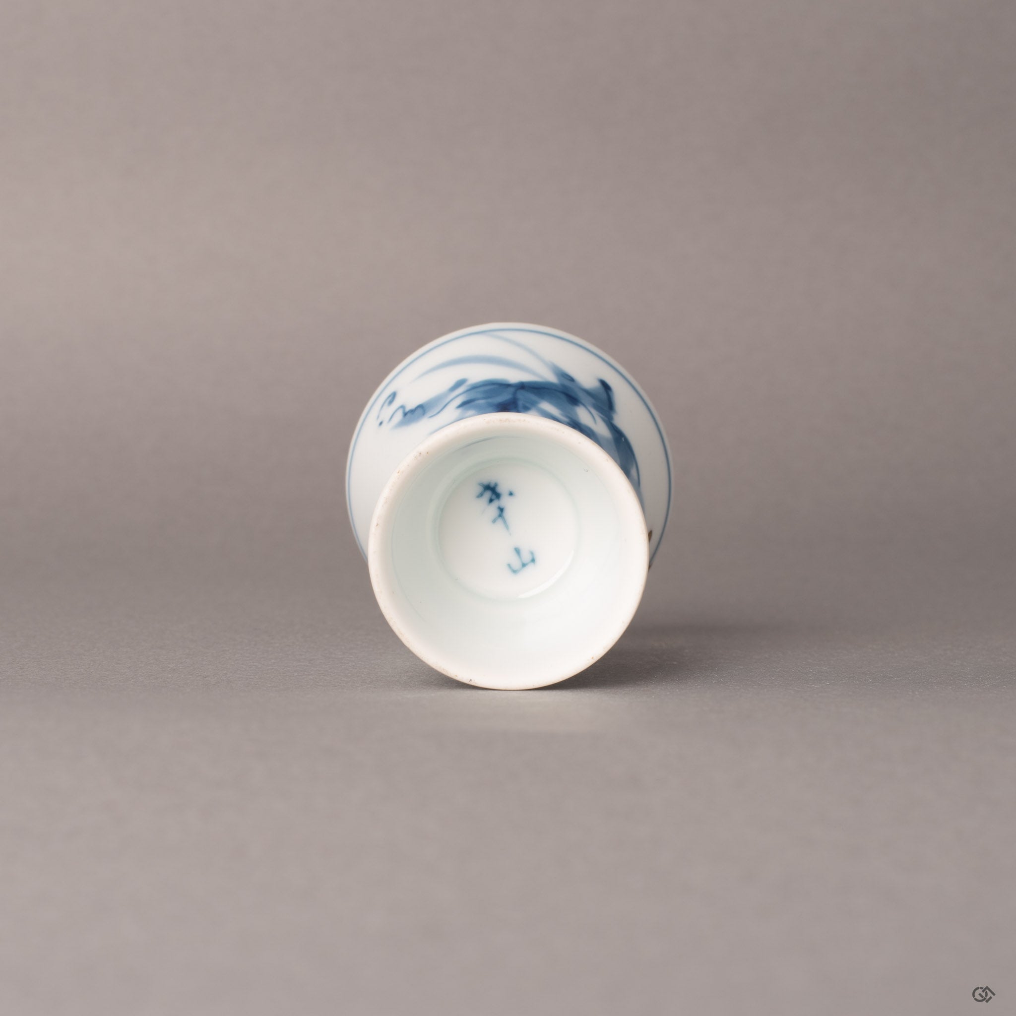 Bottom of a kintsugi Ko-Imari sake cup showing foot ring and gold restoration line, patina of time.