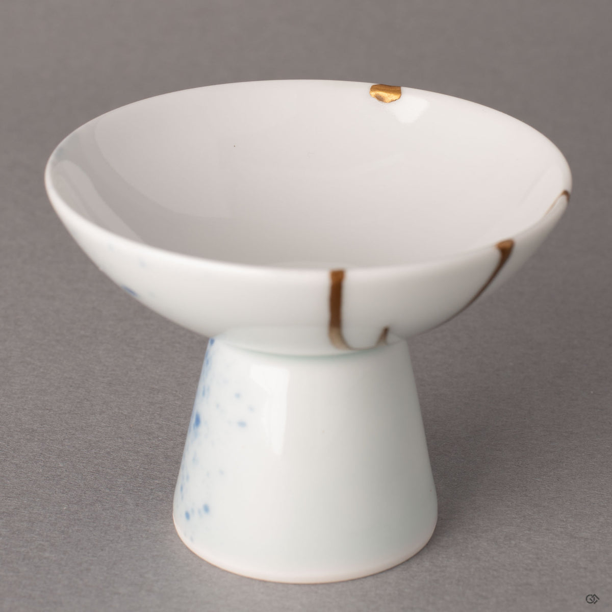 Interior detail of a kintsugi Arita sake cup showing a restored chip finished with 24K gold over urushi lacquer, tactile history in porcelain.