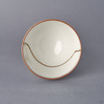 Top-down view into the Arita ware sake cup, a sweeping 24K gold kintsugi seam arcing across the white porcelain interior within an iron-brown rim line.
