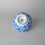 Underside of an Edo-period Ko-Imari sake cup with a cobalt mark inside the worn footring, karakusa vines and a gold kintsugi seam on the body.