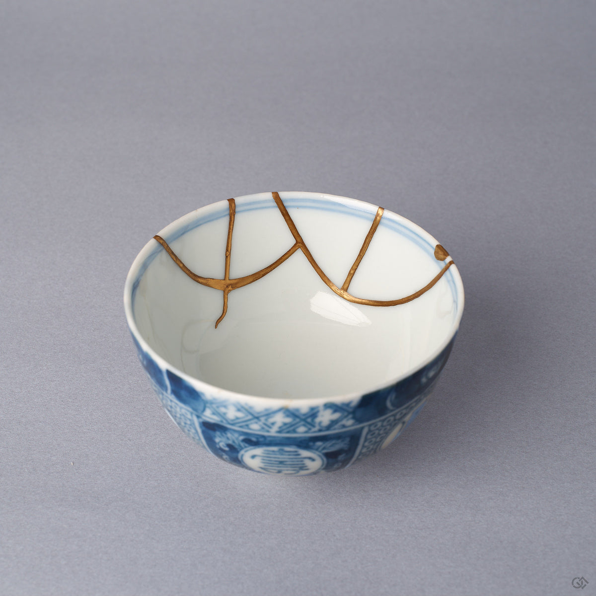 Interior close-up of a Ko-Imari sake cup, two 24K gold kintsugi arcs meeting inside the white glazed wall just below the blue rim line, restored with natural urushi.