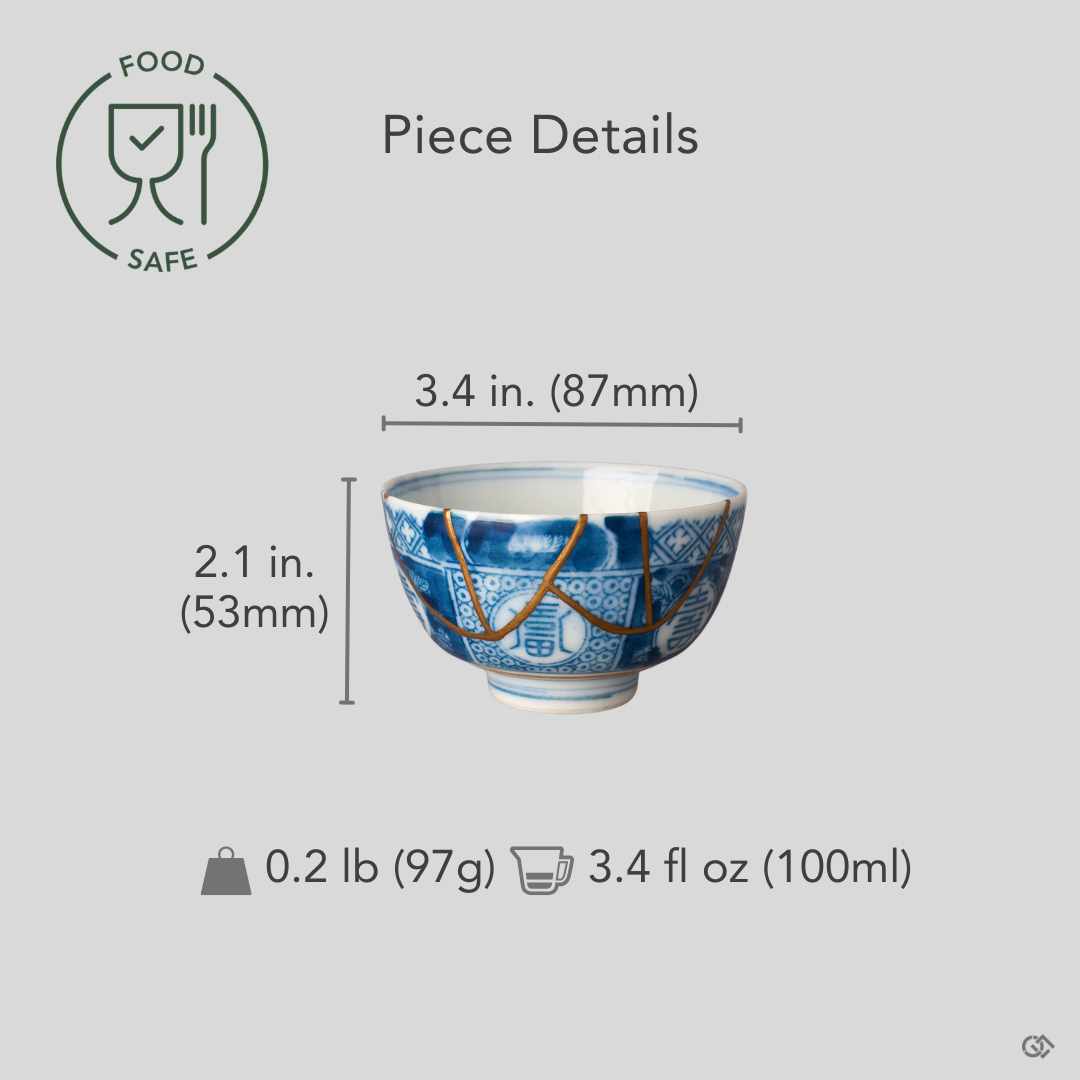 Ko-Imari sake cup in blue and white sometsuke porcelain with 24K gold kintsugi seams, restored with natural urushi, shown beside an object for scale reference.