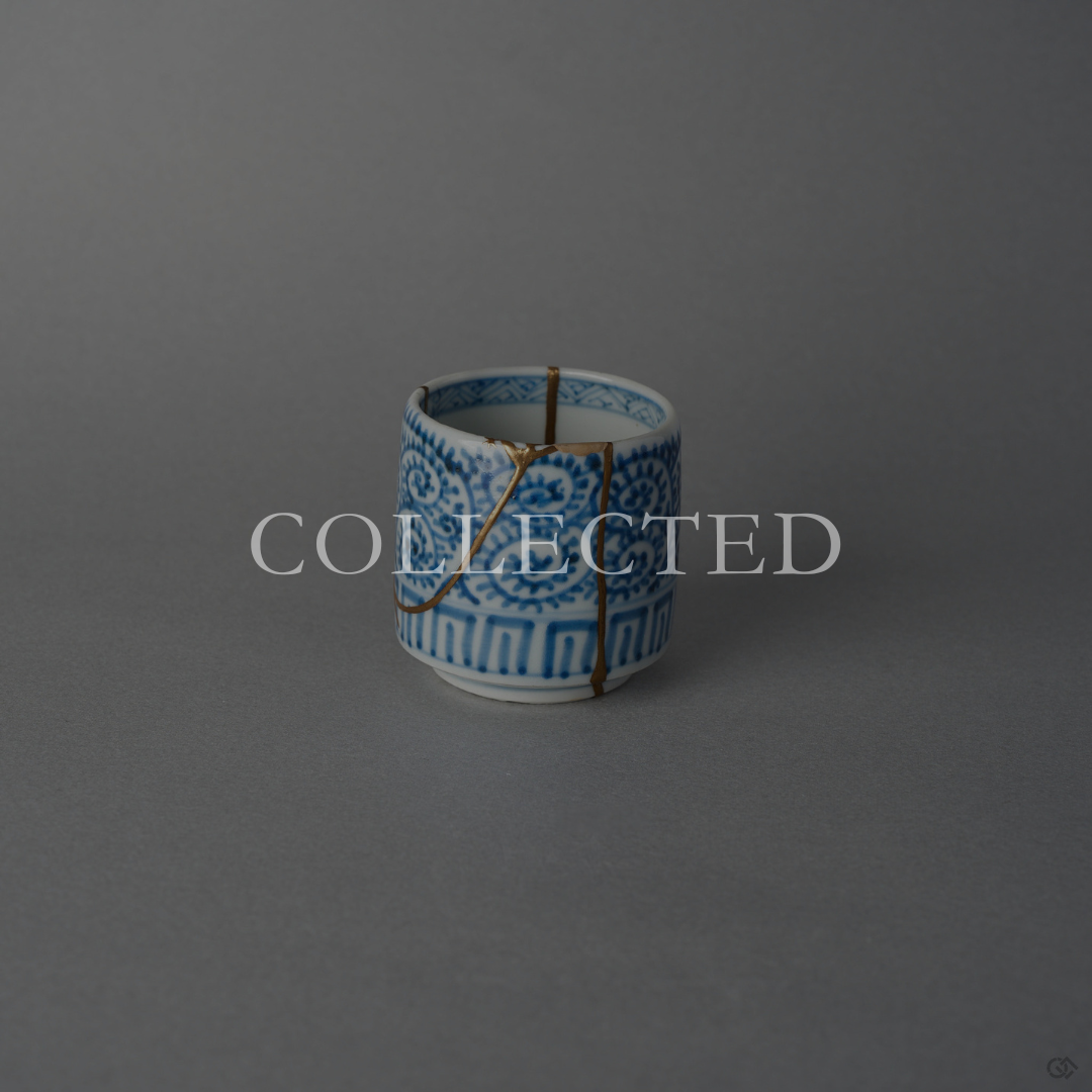 Ko-Imari sake cup in sometsuke blue takokarakusa porcelain with 24K gold kintsugi lines and cloud motifs in raised lacquer at the rim, restored with natural urushi. Collected.