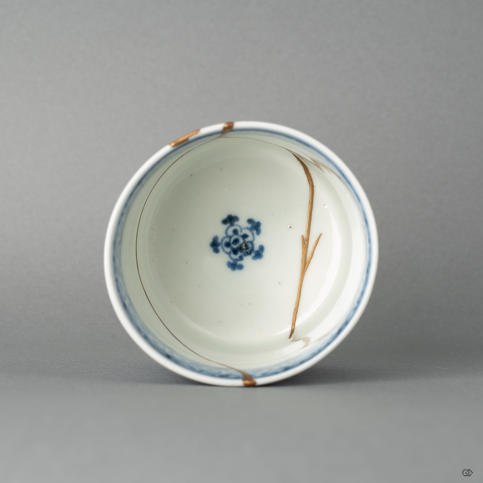 Top-down view reveals the delicate rim and seamless gold kintsugi lines; a quiet beauty is made visible through restoration.