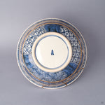 Underside of the sometsuke porcelain serving bowl with banded patterns, a blue kiln mark on the foot, and 24K gold kintsugi lines crossing the lower body.