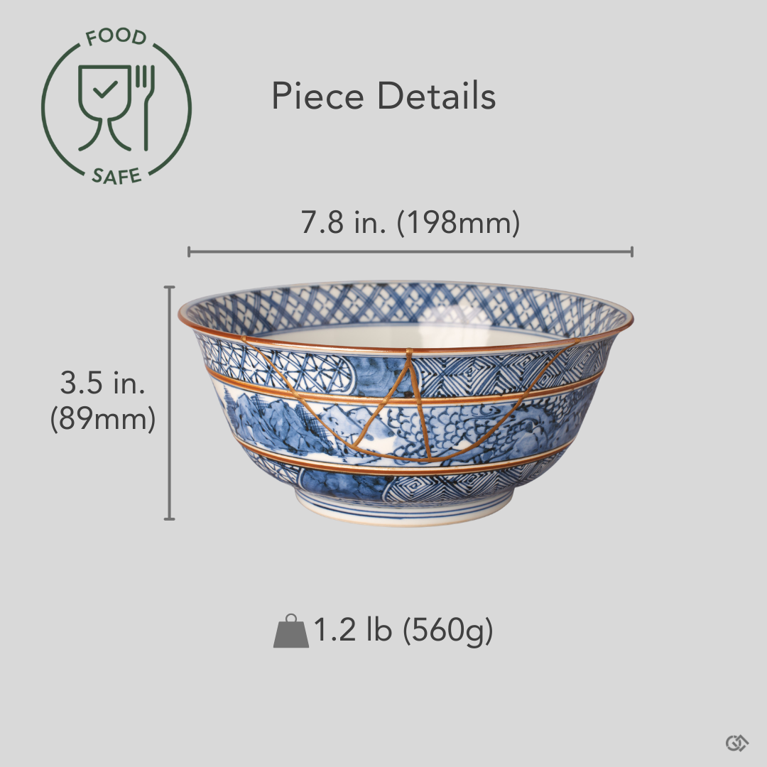 Size reference view of the twenty-centimeter Kyoto ware kintsugi serving bowl in hand-painted sometsuke blue with its branching 24K gold restored seam.