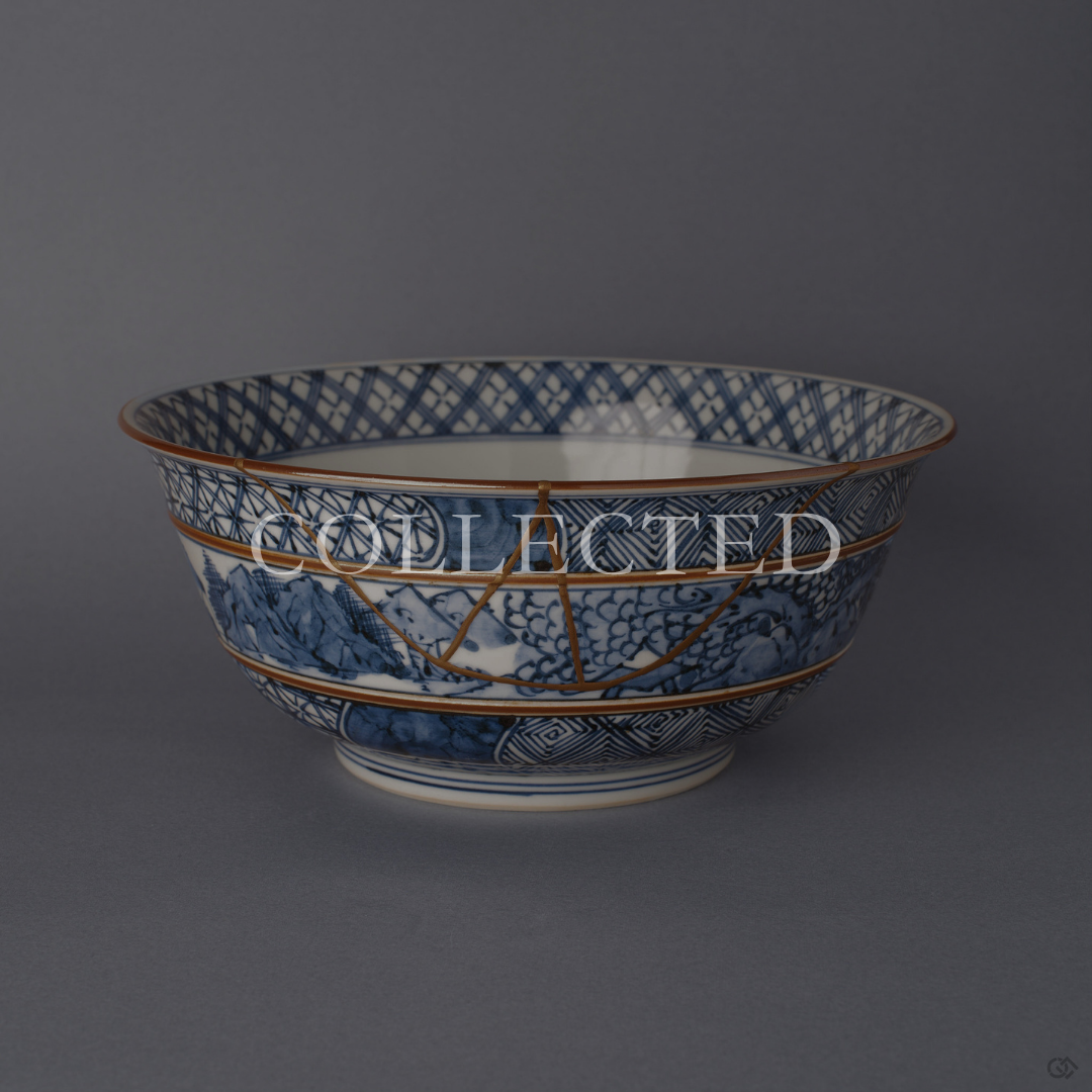 Kyoto ware porcelain serving bowl painted in sometsuke blue, its branching 24K gold kintsugi seam descending from the rim across banded patterns. Sold out.