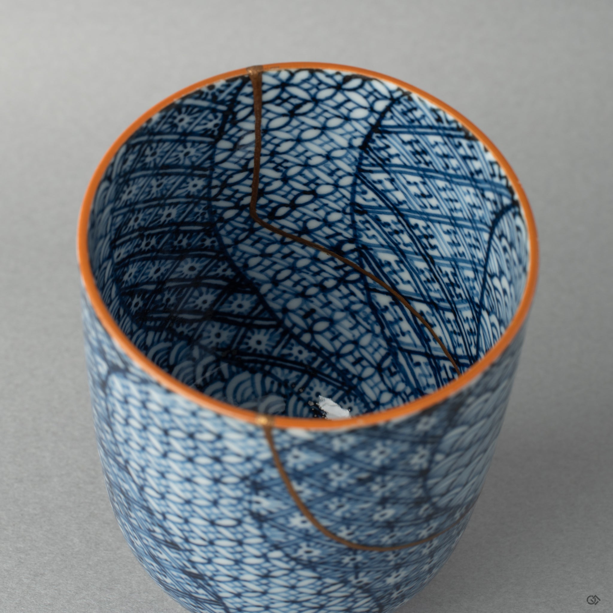 Interior close-up of gold kintsugi seams catching soft light, the mended surface revealing history made visible.