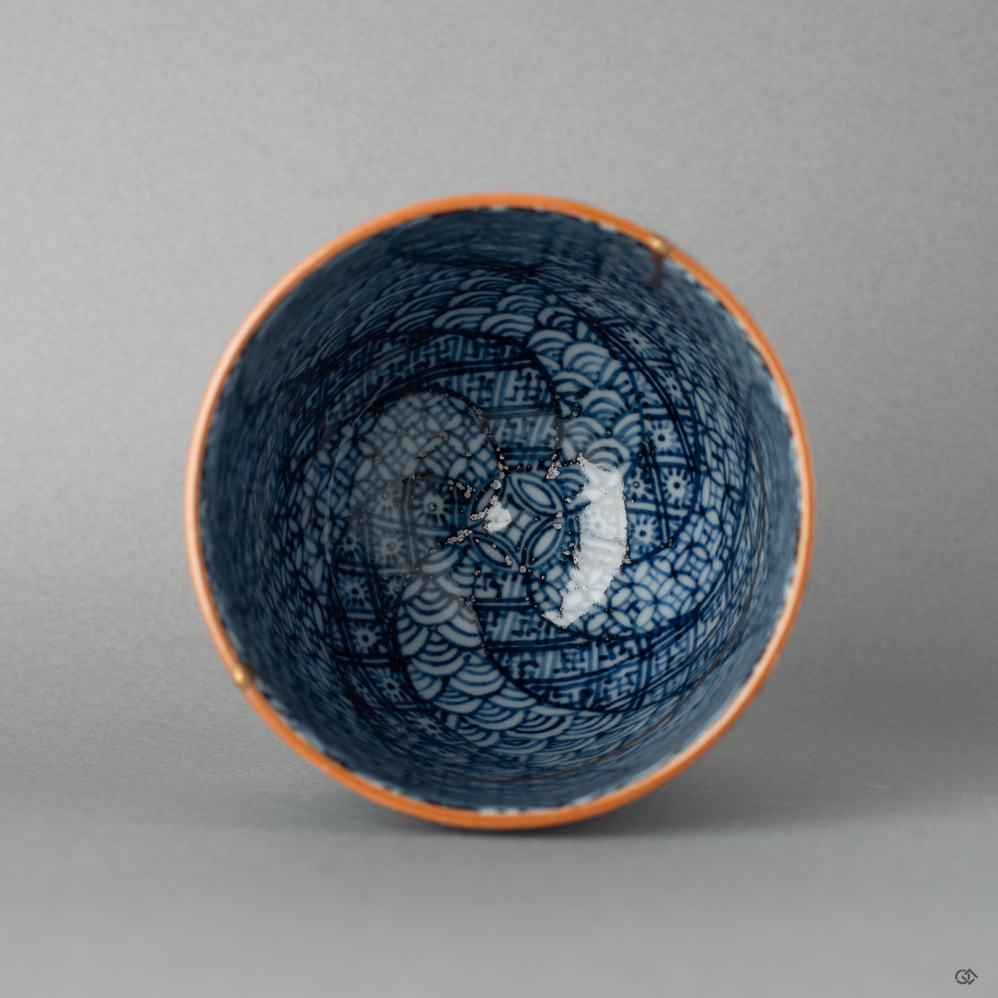 Top view of a Kyoto kintsugi tea cup, gold seams tracing the rim in a pattern that speaks to beauty in imperfection.