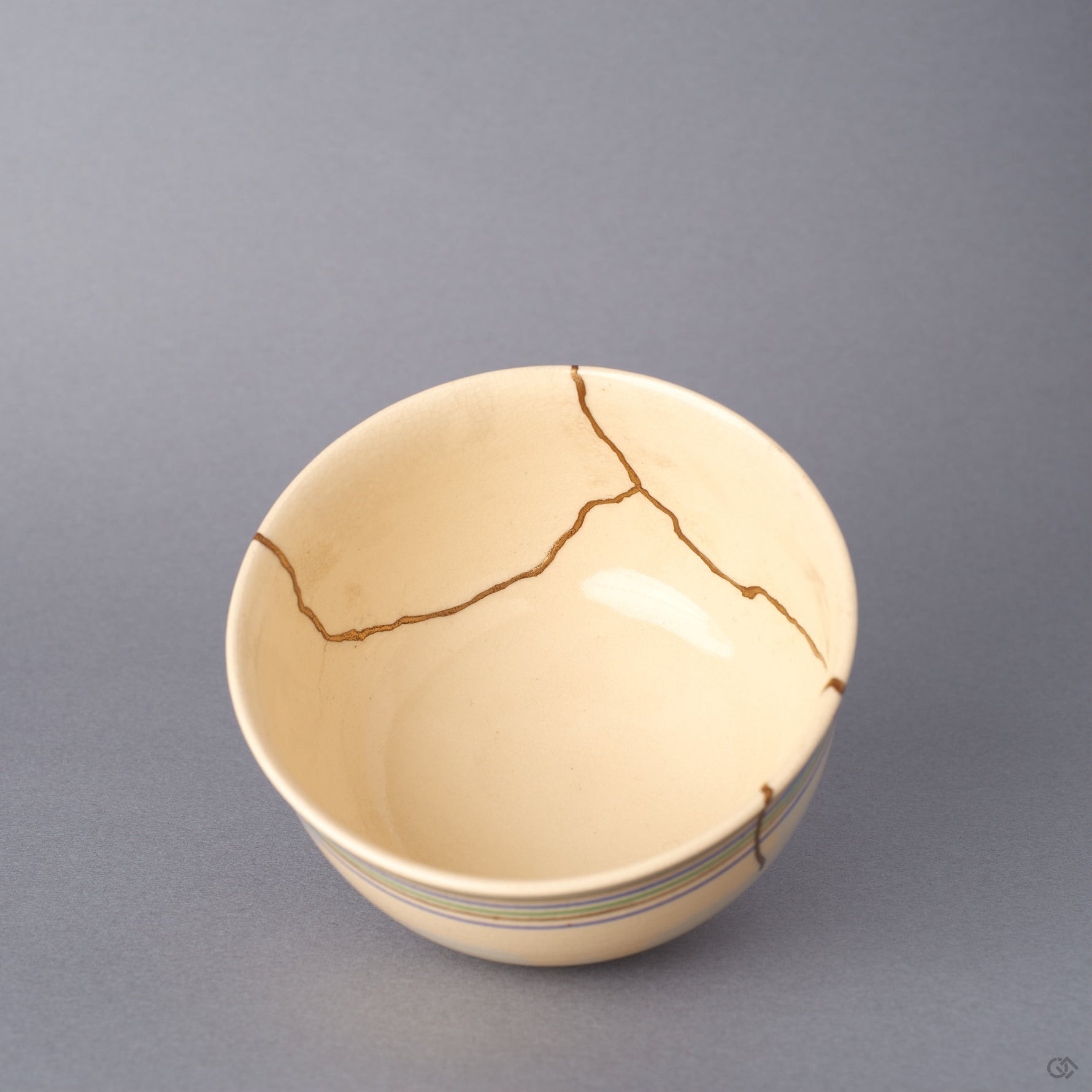Interior close-up of the Kyoto ware kintsugi cup, showing the cream glaze, fine crackle, and a 24K gold seam crossing the inner rim where the earthenware was restored.