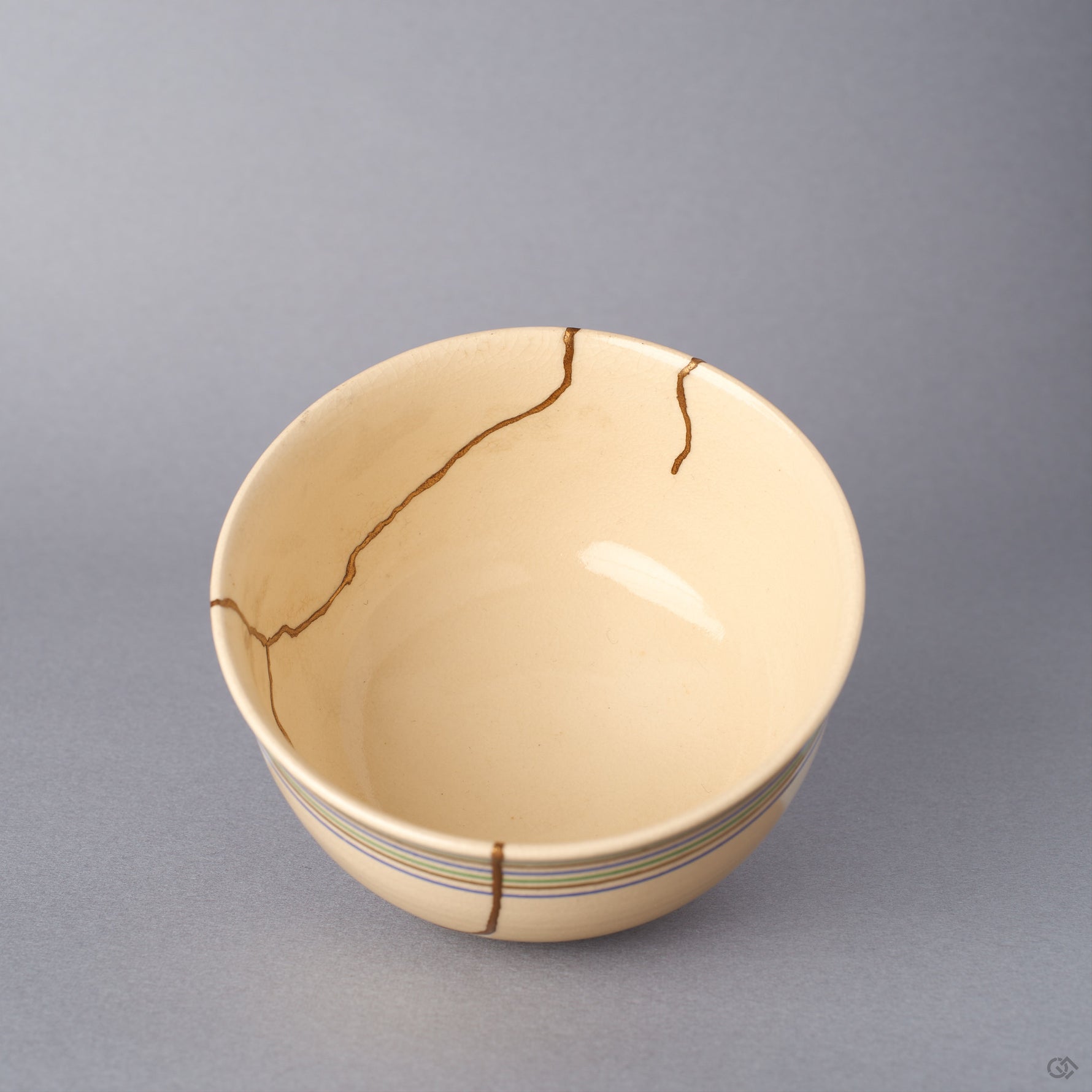 Close-up inside the cream colored Kyoto ware kintsugi cup, detailing the soft crackle glaze and the gold-finished seams of the natural urushi restoration in 24K gold.