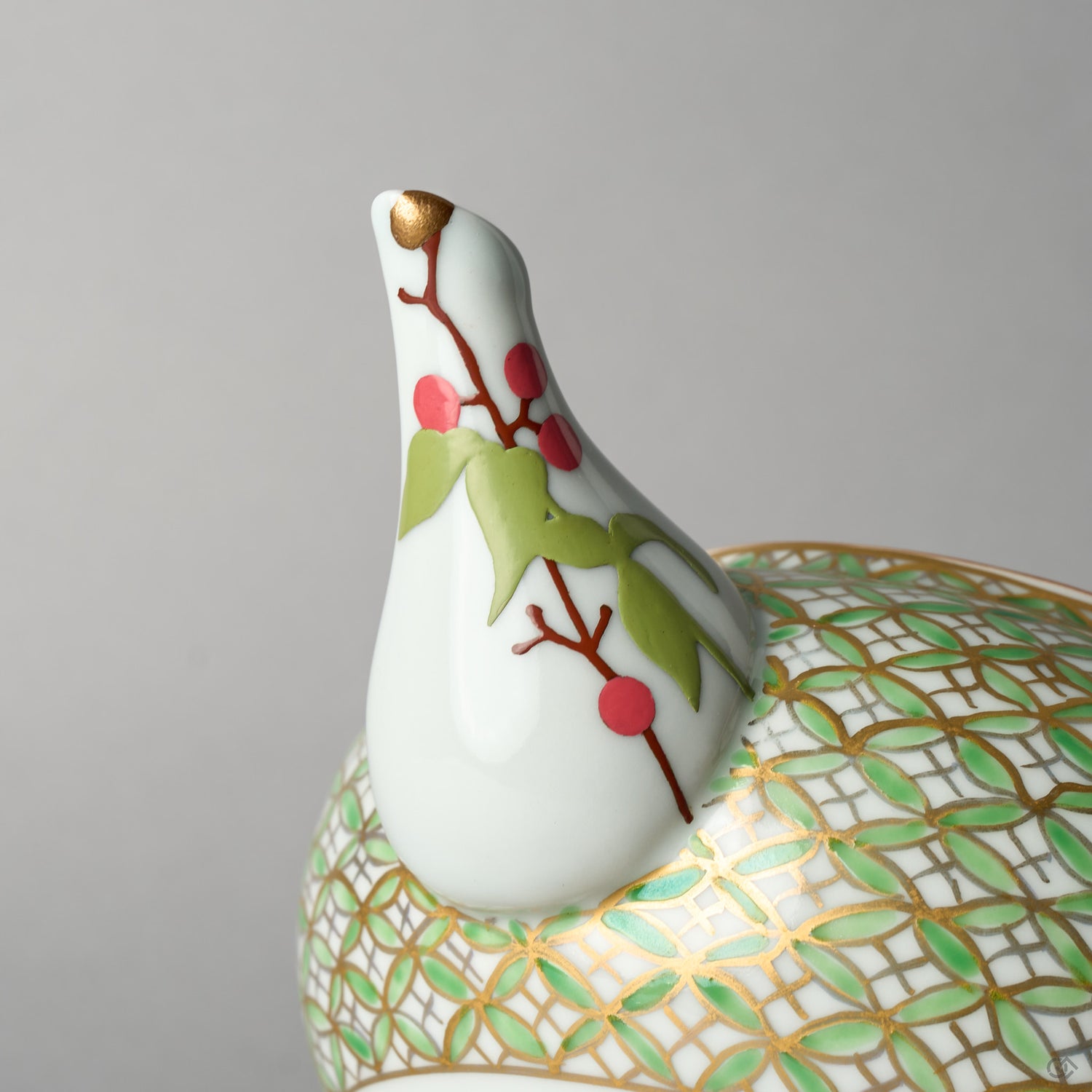 Close-up of the kintsugi restoration on the Kyoto teapot spout: the chip rebuilt with urushi, finished in 24K gold at the tip, and painted with nandina berries in urushi-e.