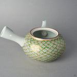 Side view of the Kyoto ware kintsugi teapot showing the white side handle, the gilded shippo lattice in green enamel, and the nandina-painted spout tipped in 24K gold.